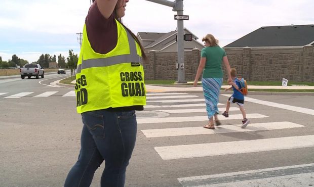 FILE: Crossing guard Megan Sperry helps students across 2100 North in Lehi, a four-lane highway chi...