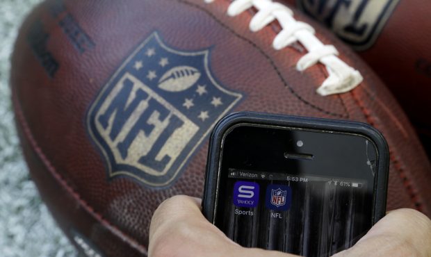 In this Thursday, Aug. 30, 2018, photo apps for NFL and Yahoo Sports are displayed on a phone on th...