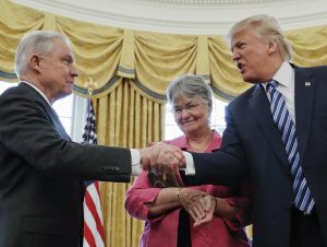 FILE - In this  Feb. 9, 2017 file photo, President Donald Trump shakes hands with Attorney General Jeff Sessions, accompanied by his wife Mary, after he was sworn-in by Vice President Mike Pence, in the Oval Office of the White House in Washington. On Nov. 7, 2018, Sessions submitted his resignation in letter to Trump. (AP Photo/Pablo Martinez Monsivais, File)