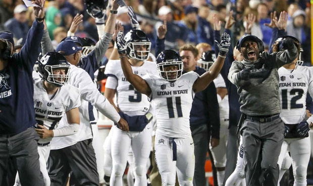 The Utah State Aggies bench celebrates a touchdown during the Utah State versus BYU football game a...