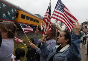 NAVASOTA, TEXAS - DECEMBER 06: People wave at the train carrying the casket of former U.S. President George H.W. Bush to the George H.W. Bush Presidential Library at Texas A&M University on December 6, 2018 in Navasota, Texas. President Bush will be buried at his final resting place at the George H.W. Bush Presidential Library at Texas A&M University in College Station, Texas. A WWII combat veteran, Bush served as a member of Congress from Texas, ambassador to the United Nations, director of the CIA, vice president and 41st president of the United States. (Photo by Justin Sullivan/Getty Images)