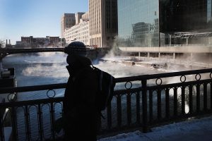 A commuter walks through downtown in sub-zero temperatures during an extremely light morning rush hour on January 30, 2019 in Chicago, Illinois. Businesses and schools have closed, Amtrak has suspended service into the city, more than a thousand flights have been cancelled and mail delivery has been suspended as the city copes with record-setting low temperatures. (Photo by Scott Olson/Getty Images)