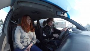 Tori Merrill sits in the passenger seat of her car while she teaches her son, Logan Merrill, how to drive.