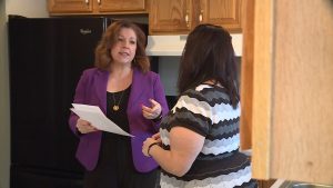 Realtor Jennifer Gilchrist reviews a disclosure form with her client, Marie Cornett.