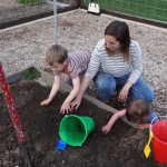 Katie Foerster prepares the soil for their garden plot at the Orem Community Hospital's LiVe Well Garden.