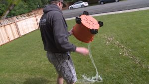 Bryan Stewart dumping a bucket of water