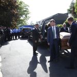 WAYNESVILLE, NC - MAY 05: Family, friends and a law enforcement honor guard look on as a casket carrying Riley Howell, a UNC Charlotte student, is taken in to a service celebrating his life on May 5, 2019 in Waynesville, North Carolina. Riley Howell, an Army ROTC cadet who died last Tuesday when he tackled a gunman during a shooting at his school, was granted permission to receive military funeral honors for his heroism. (Photo by Brian Blanco/Getty Images)