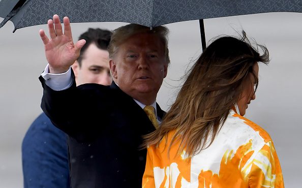 US President Donald Trump (C) waves beside First Lady Melania (R) as they depart at the Haneda Inte...