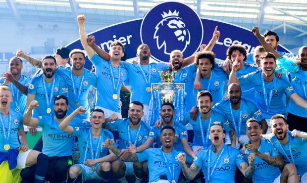 Manchester City pose with the Premier League trophy after the Premier League match between Brighton...