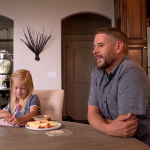 Bill Fowler sits down with his daughter, Lola Fowler, for a healthy snack and homework help.