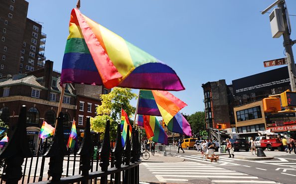 NEW YORK, NEW YORK - JUNE 26:  Rainbow pride flags fly outside the Stonewall Inn as crowds begin to...