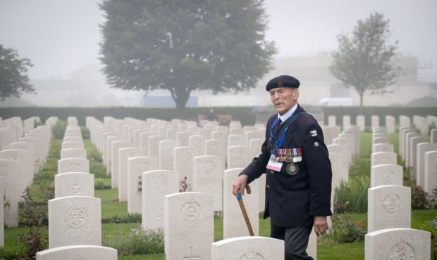 BAYEUX, FRANCE - JUNE 06: Normany veteran 98-year-old Edwin 'Ted' Hunt walks past the graves of the...