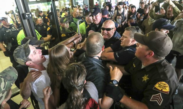 Salt Lake police and Utah Highway Patrol troopers force protesters out of the Chamber of Commerce B...