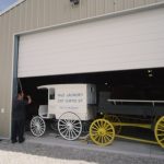 Eli Anderson opens the door of one of the buildings housing his collection of carriages.