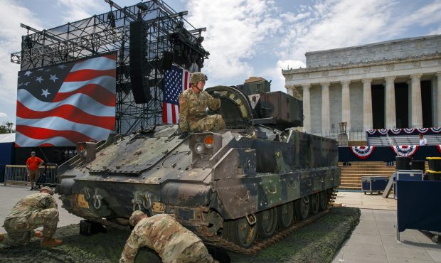 An Army soldier hops out of a Bradley Fighting Vehicle after moving it into place by the Lincoln Me...