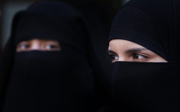 Two women wearing Islamic niqab veils stand outside the French Embassy during a demonstration in Lo...