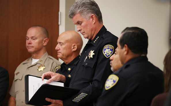 Gilroy Police Chief Scot Smithee (C) stands at a press conference the day after a mass shooting at ...