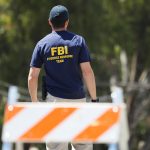 GILROY, CALIFORNIA - JULY 29: An FBI agent walks toward the site of the Gilroy Garlic Festival after a mass shooting there yesterday on July 29, 2019 in Gilroy, California.  Three victims were killed and at least a dozen were wounded before police officers killed the suspect. (Photo by Mario Tama/Getty Images)