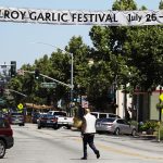 GILROY, CALIFORNIA - JULY 29: A man walks beneath a sign advertising the nearby Gilroy Garlic Festival after a mass shooting took place at the event yesterday on July 29, 2019 in Gilroy, California.  Three victims were killed and at least a dozen were wounded before police officers killed the suspect. (Photo by Mario Tama/Getty Images)