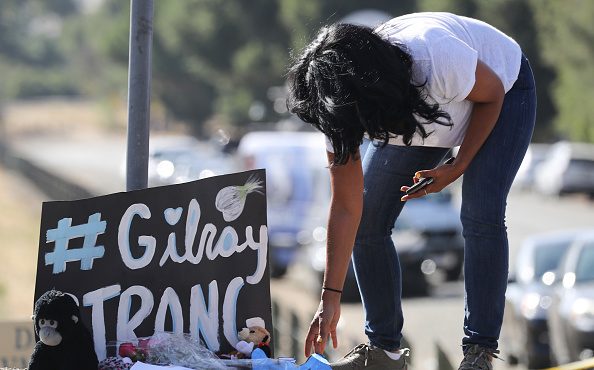 GILROY, CALIFORNIA - JULY 29: A woman leaves mementos at a makeshift memorial outside the site of t...