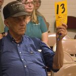 A customer raises a numbered card to place a bid at Taylor's auction house in Ogden.