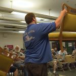 Taylor's employees hold up furniture for the crowd before bidding begins.