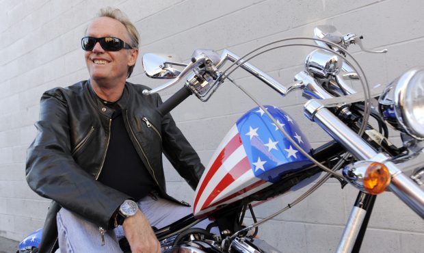 FILE - In this Friday, Oct. 23, 2009 file photo, Peter Fonda, poses atop a Harley-Davidson motorcyc...