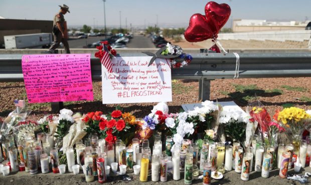A police officer walks past a makeshift memorial outside Walmart, near the scene of a mass shooting...