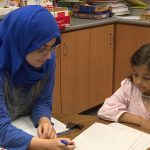 Baraa Arkawazi helps a student at East Midvale Elementary.
