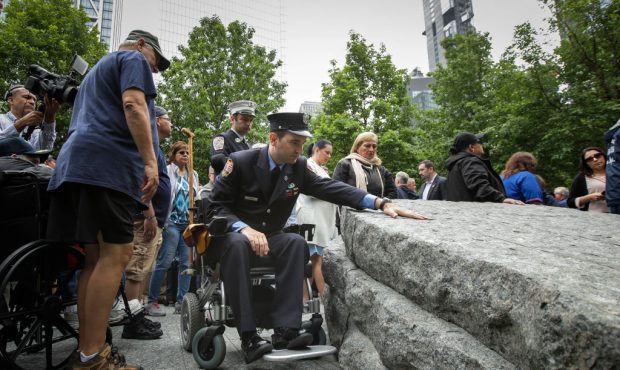 Retired FDNY firefighter and 9/11 first responder Rob Serra touches one of the stone monoliths foll...