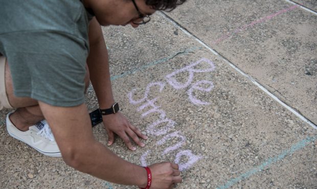 Juan Perez, 17, writes with chalk during a vigil at the University of Texas of the Permian Basin (U...