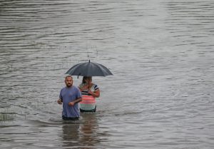 People walk the flooded waters Hopper Rd. on  September 19, 2019 in Houston, Texas. Gov. Greg Abbott has declared much of Southeast Texas disaster areas after heavy rain and flooding from the remnants of Tropical Depression Imelda dumped more than two feet of water across some areas. (Photo by Thomas B. Shea/Getty Images)