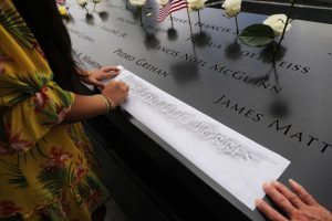 The niece of Luis Eduardo Torres, who was killed while working as a broker at Cantor Fitzgerald, copies out his name at the National September 11 Memorial during a morning commemoration ceremony for the victims of the terrorist attacks Eighteen years after the day on September 11, 2019 in New York City. Throughout the country services are being held to remember the 2,977 people who were killed in New York, the Pentagon and in a field in rural Pennsylvania. (Photo by Spencer Platt/Getty Images)