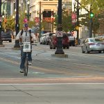 Scott Schwarz rides his bike while playing his drum down Main Street in Salt Lake City.