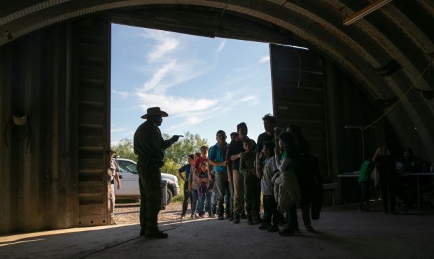 A U.S. Border Patrol agent gives instructions to families, mostly from Central America, who had cro...