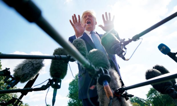 U.S. President Donald Trump talks to journalists on the South Lawn of the White House before boardi...