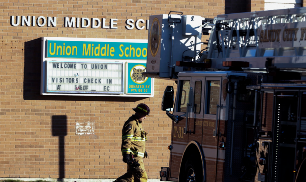 A Sandy firefighter walks out of Union Middle School following a small electrical fire on Tursday, ...