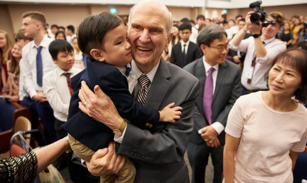 Three-year-old Tate Chan gives Church President Russell M. Nelson a hug following a devotional in S...