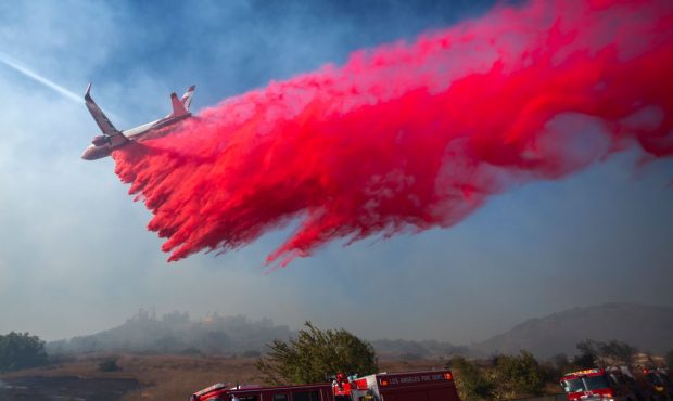 SIMI VALLEY, CA - OCTOBER 30: A firefighting jet drop retardant over a threatened neighborhood afte...