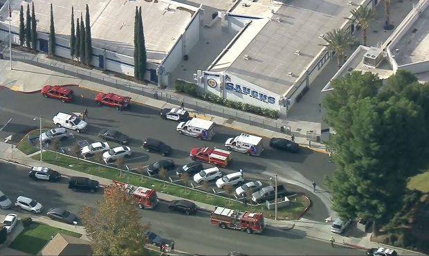 Emergency vehicles are parked outside Saugus High School in Santa Clarita on Thursday morning. (KCA...