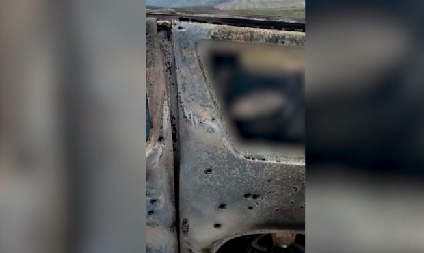Video of the scene shows a car burned and full of bullet holes after a group of people were killed ...