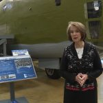 Carolyn Toronto speaks about her father while standing next to a B-24 at the Hill Aerospace Museum.