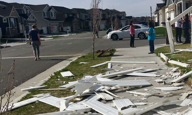 Residents look at the remains of a shattered fence in South Jordan....