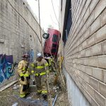 A vehicle that drove off a parking structure in the downtown area became stuck between two buildings, authorities said. (Photo: Salt Lake City Fire Department)