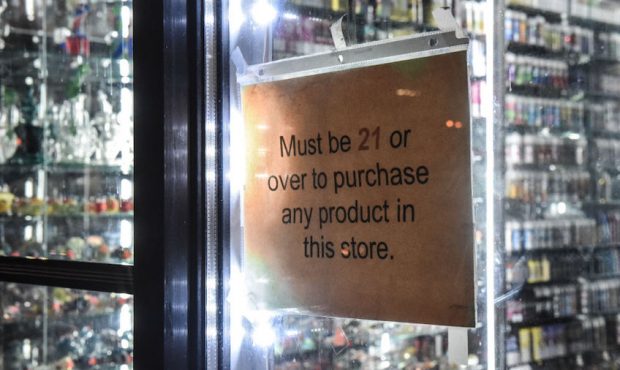 A sign that states "must be over 21" hangs in the store window of a vape shop on December 19, 2019 ...
