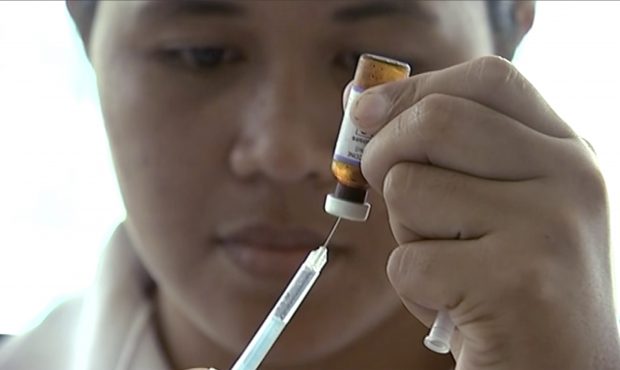 In this image made from video, a New Zealand health official prepares a measles vaccination at a cl...