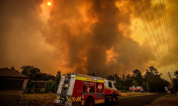 Firemen prepare as a bushfire approaches homes on the outskirts of the town of Bargo on December 21...