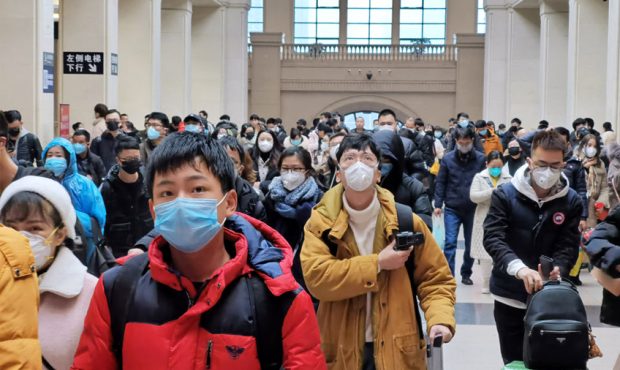 People wear face masks as they wait at Hankou Railway Station on January 22, 2020 in Wuhan, China. ...