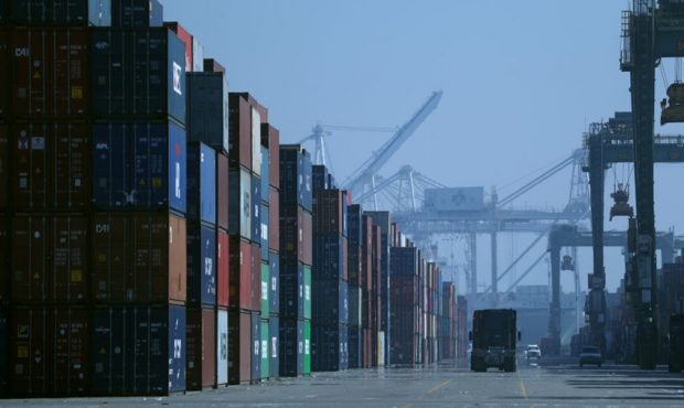 FILE — A truck drives past stacks of shipping containers at the Port of Oakland on November 18, 2...