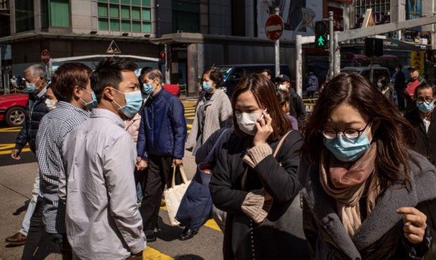 Residents wear surgical mask as they cross a street in a shopping district on January 31, 2020 in H...